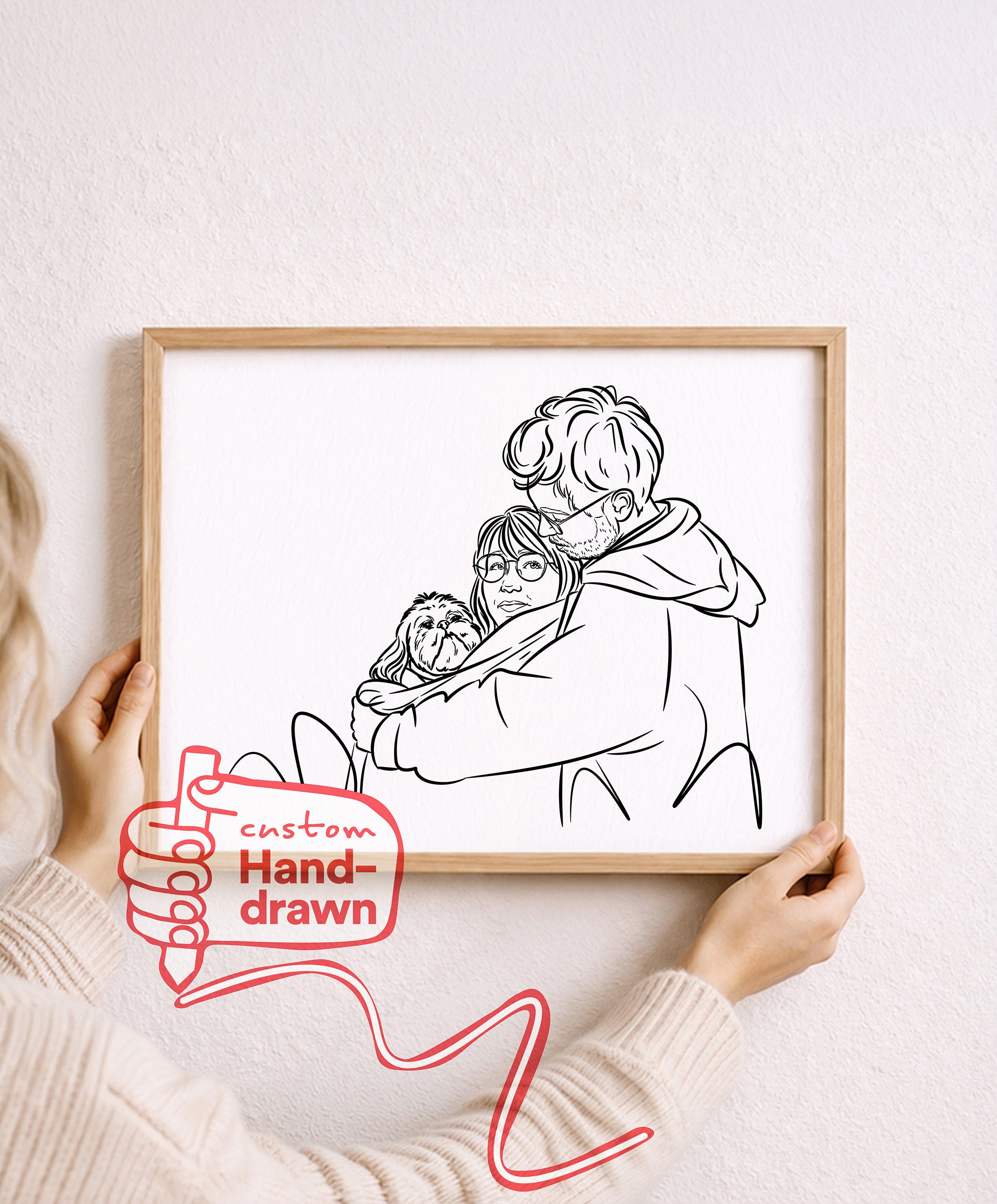 Just Line hand-drawn couple portrait with their dog, framed oak print held against a pale wall